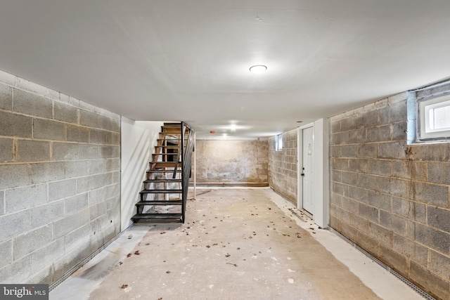 below grade area featuring concrete block wall and stairs