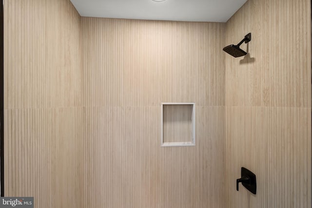 interior details featuring tiled shower