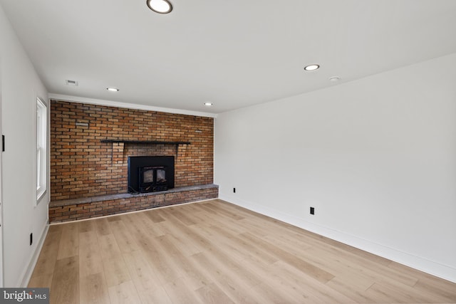 unfurnished living room featuring baseboards, light wood-style floors, and a fireplace