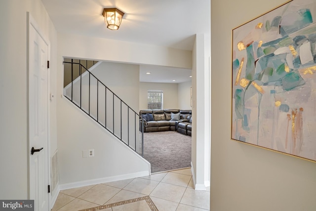 foyer entrance featuring light tile patterned floors, recessed lighting, stairway, light carpet, and baseboards