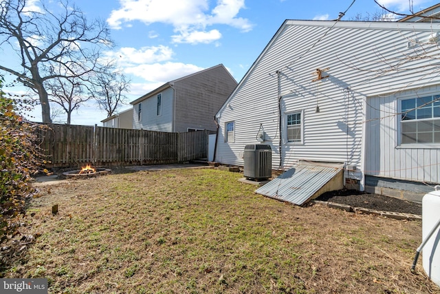 view of yard with cooling unit, an outdoor fire pit, and fence