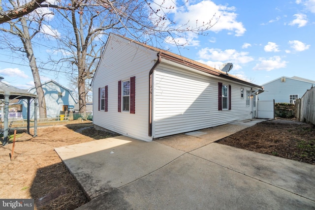 view of side of home featuring a patio area and fence