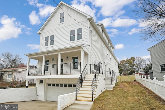 view of front of house with a garage, concrete driveway, stairway, fence, and board and batten siding