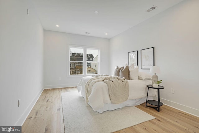 bedroom featuring light wood-style floors, visible vents, baseboards, and recessed lighting