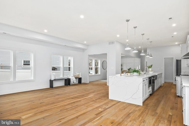 kitchen with visible vents, light wood-style floors, pendant lighting, a sink, and recessed lighting