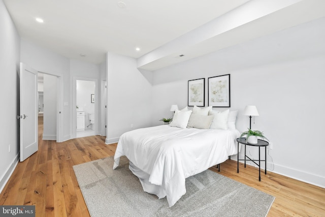 bedroom featuring light wood-type flooring, ensuite bathroom, baseboards, and recessed lighting