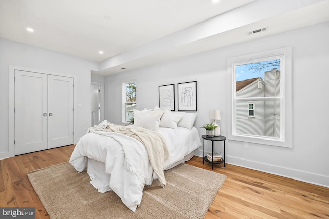 bedroom featuring baseboards, visible vents, wood finished floors, and recessed lighting