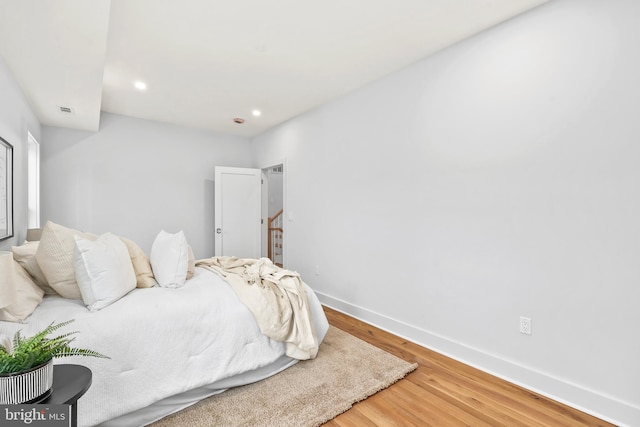 bedroom featuring baseboards, wood finished floors, and recessed lighting