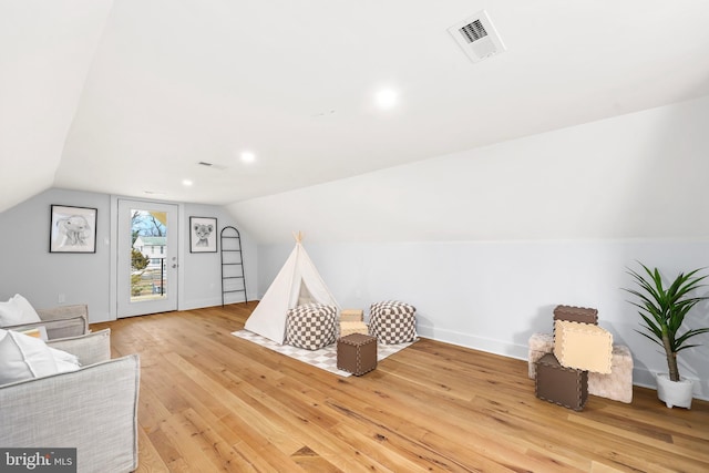 playroom featuring light wood-type flooring, visible vents, and lofted ceiling