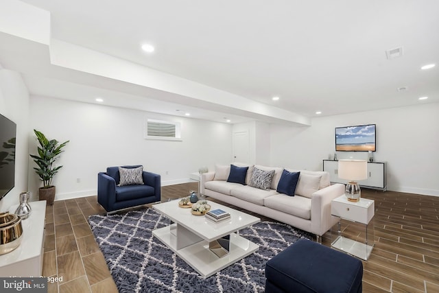 living area featuring wood tiled floor, visible vents, baseboards, and recessed lighting