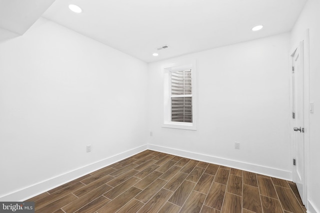 empty room with wood finish floors, recessed lighting, visible vents, and baseboards