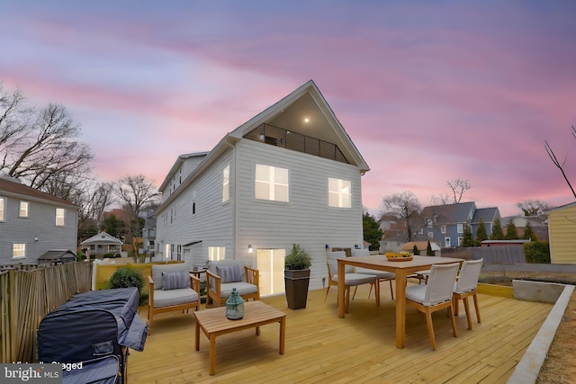 back of house with a deck, outdoor dining space, and fence