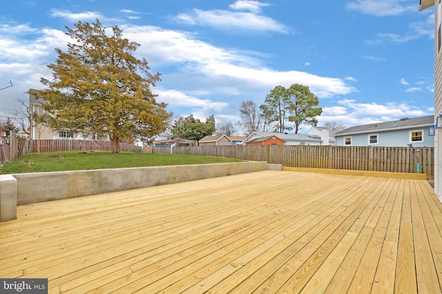 wooden deck featuring a fenced backyard, a residential view, and a yard