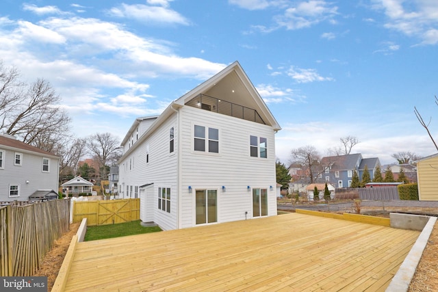 rear view of property featuring fence and a deck