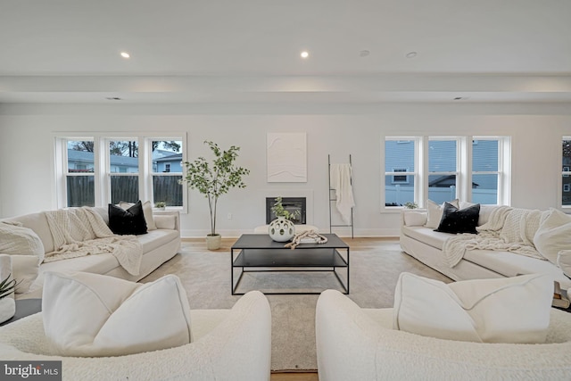 living room featuring recessed lighting, a fireplace, and light wood finished floors