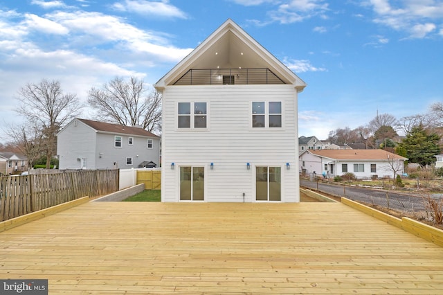 rear view of house featuring a residential view, fence, and a deck