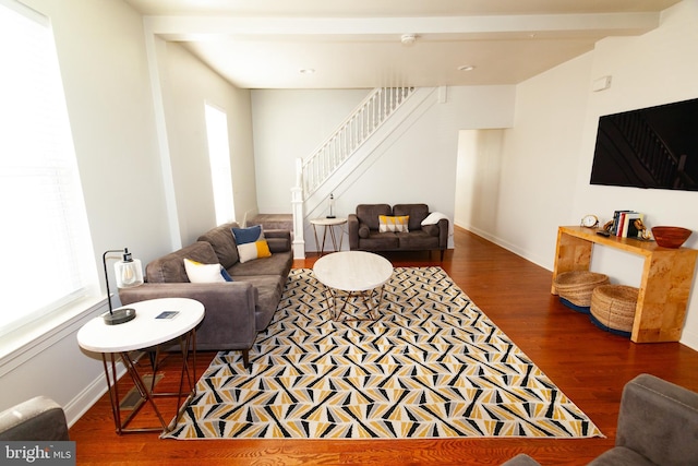 living room featuring plenty of natural light, stairs, baseboards, and wood finished floors