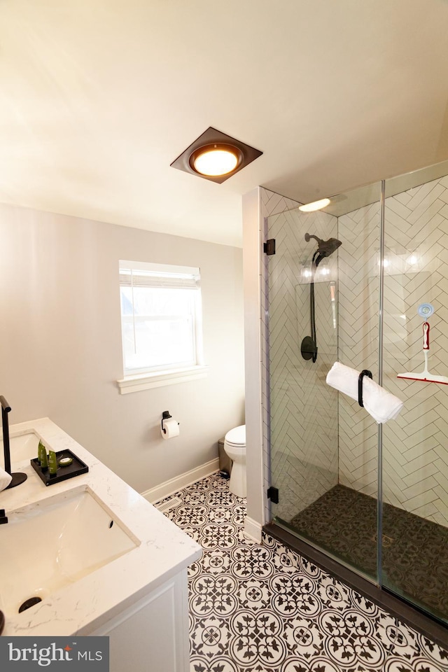 full bath featuring a stall shower, tile patterned flooring, a sink, and toilet