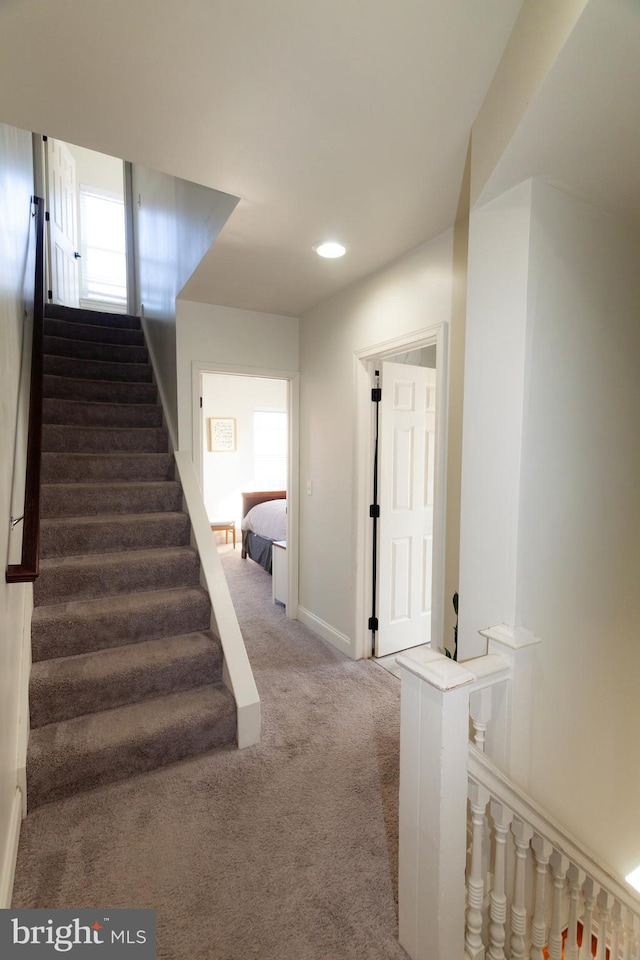 staircase featuring carpet and baseboards