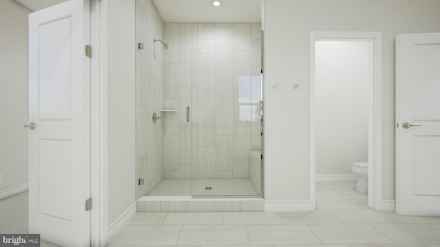 bathroom with a shower stall, baseboards, and toilet