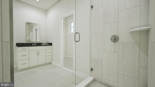 full bathroom with a shower, vanity, and baseboards