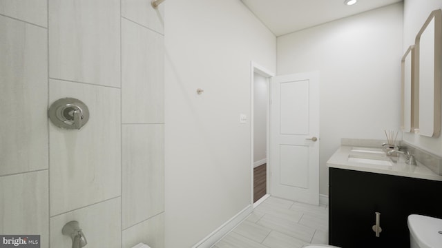 full bath featuring toilet, walk in shower, vanity, and baseboards