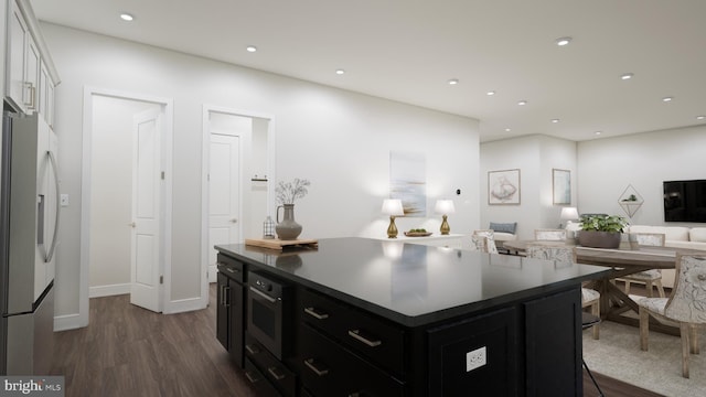 kitchen with white fridge with ice dispenser, dark wood finished floors, recessed lighting, dark cabinetry, and open floor plan