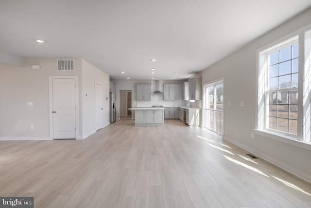 unfurnished living room featuring recessed lighting, light wood-type flooring, visible vents, and baseboards