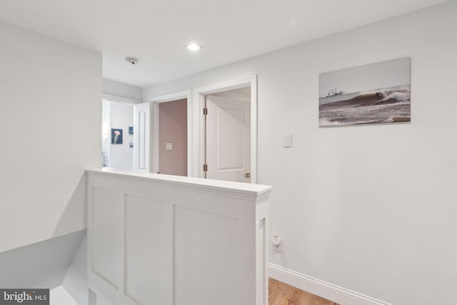 hall with recessed lighting, light wood finished floors, and baseboards