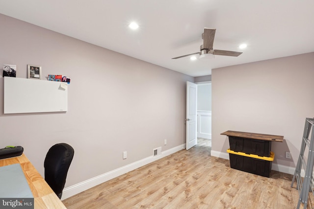 office featuring a ceiling fan, visible vents, light wood-style flooring, and baseboards