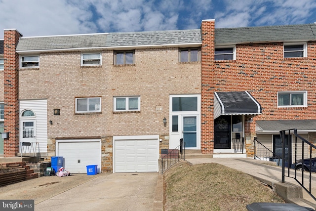 view of building exterior featuring a garage and concrete driveway