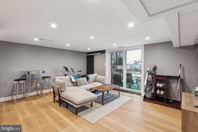 living area with baseboards, light wood-type flooring, and recessed lighting