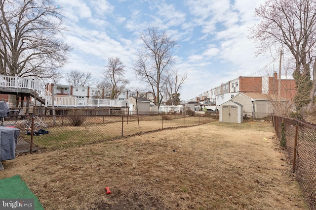 view of yard with a residential view, a fenced backyard, an outdoor structure, and a shed