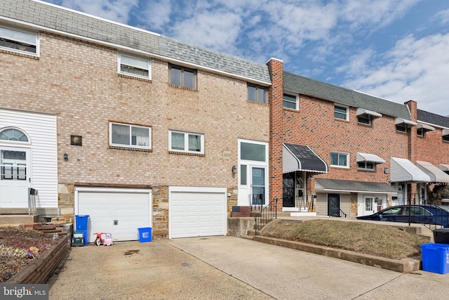 view of building exterior featuring an attached garage and concrete driveway