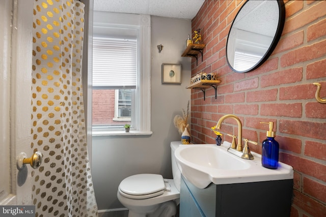 bathroom featuring toilet, brick wall, a shower, and vanity