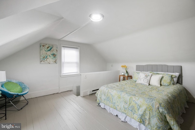 bedroom with lofted ceiling, baseboards, and wood finished floors