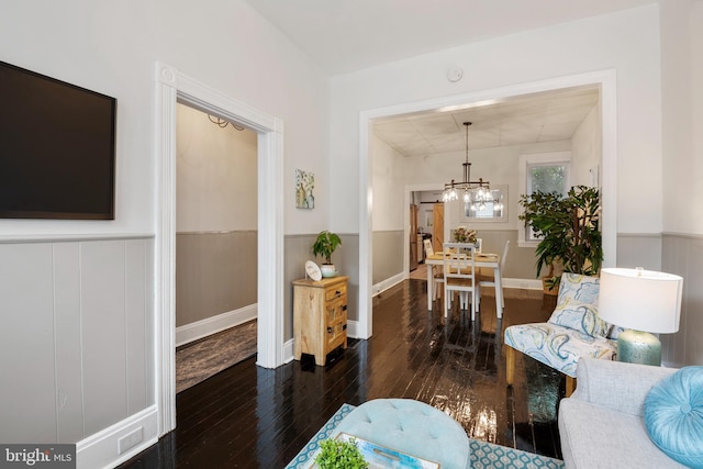 interior space featuring a wainscoted wall, hardwood / wood-style floors, and a chandelier