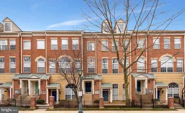 view of front of house with a fenced front yard and brick siding