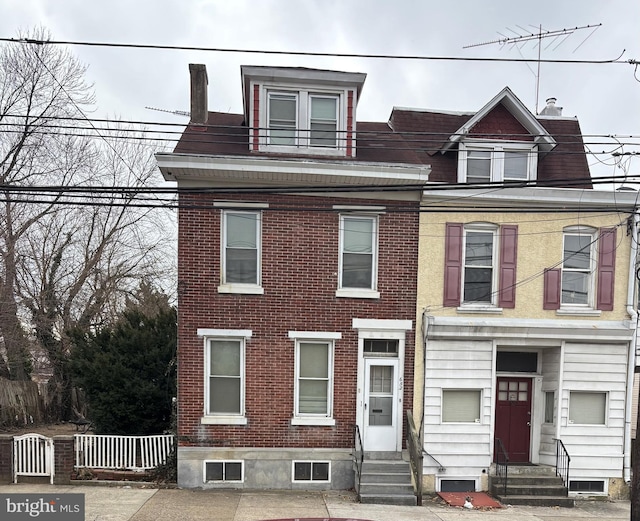 view of front of house with entry steps and brick siding