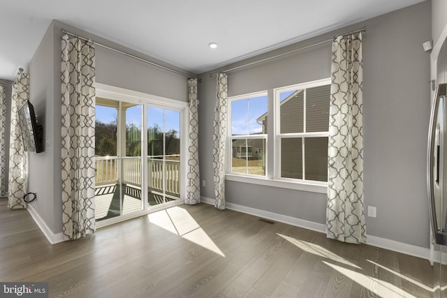 interior space with visible vents, baseboards, and wood finished floors