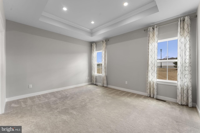 carpeted empty room featuring baseboards, a tray ceiling, and recessed lighting