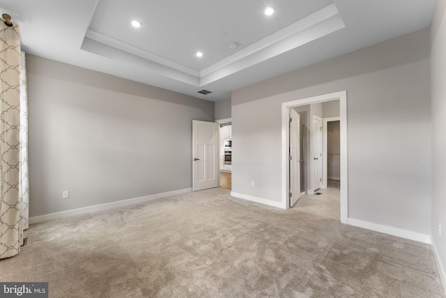 unfurnished bedroom with carpet floors, recessed lighting, a raised ceiling, visible vents, and baseboards