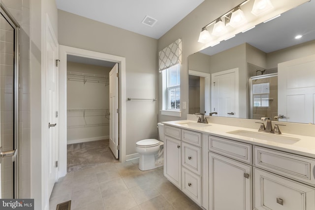 full bathroom with a spacious closet, a stall shower, a sink, and visible vents