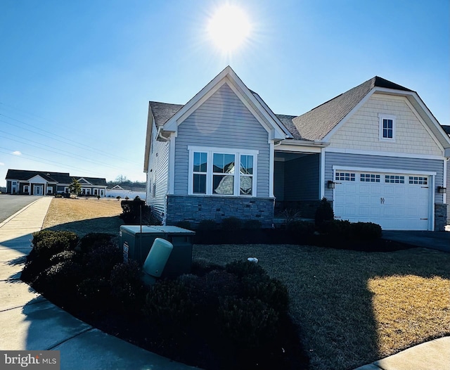 view of front facade with a garage, stone siding, and driveway