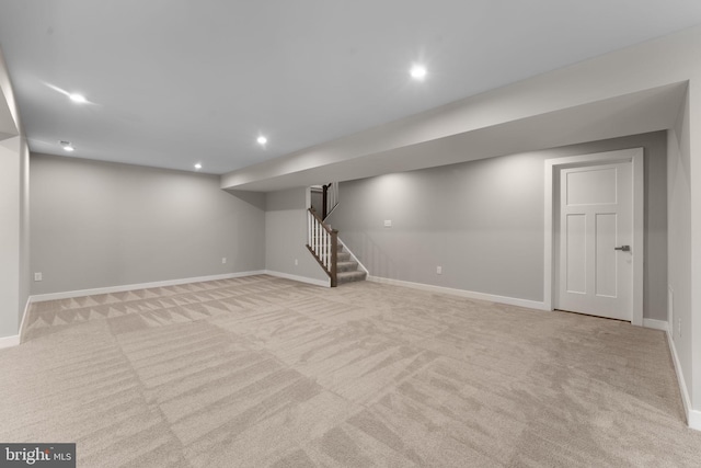 finished below grade area with stairs, carpet floors, baseboards, and recessed lighting