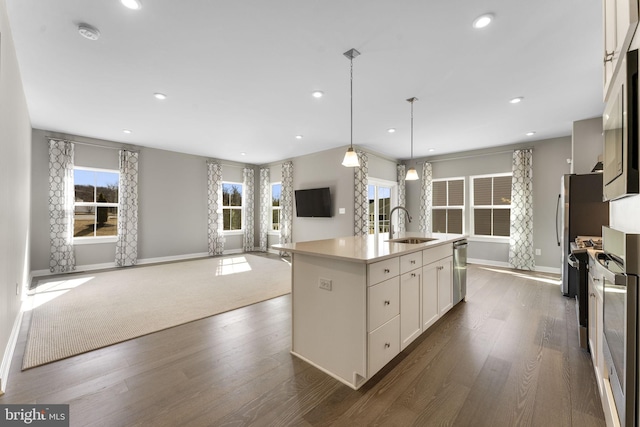 kitchen featuring dark wood-style flooring, white cabinets, a sink, and open floor plan