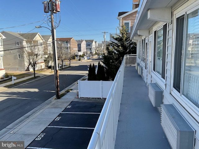 view of street featuring street lighting, a residential view, curbs, and sidewalks