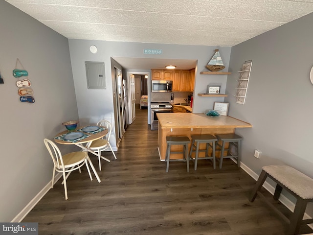 dining space with a textured ceiling, dark wood finished floors, electric panel, and baseboards