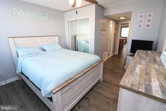 bedroom with visible vents, baseboards, dark wood-style floors, ceiling fan, and a closet