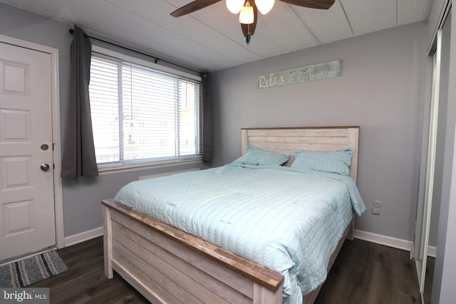 bedroom with a ceiling fan, baseboards, and wood finished floors